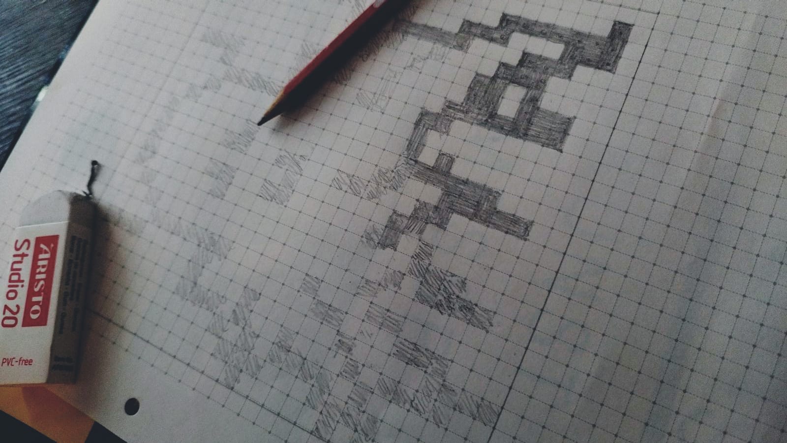 Das Bild zeigt den ersten Entwurf mittels Bleistift und kariertem Papier. Ein Radiergummi hilft beim Ausbessern von Fehlern. Zuerst werden die Kästchen zart schraffiert, anschließend stark nachgezeichnet. Der gewählte Superhero stellt einen oktopusartigen Charakter dar.